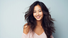 Smiling Young Asian Woman With Long Healthy Hair On Grey Background
