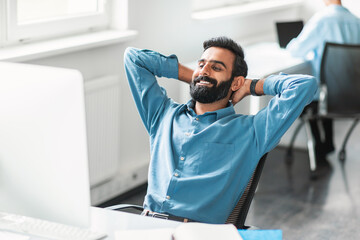 Aufkleber - Relaxed indian male office worker leaning back in his chair, smiling