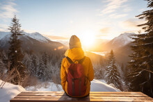 Generative AI Back View Image Of An Unrecognizable Woman In A Yellow Jacket Sitting And Observing A Sunset In A Snowy Mountain Landscape