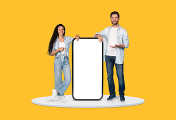 Aufkleber - Man and woman presenting large smartphone display on yellow background