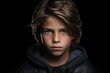 Portrait of a boy in a black jacket on a black background
