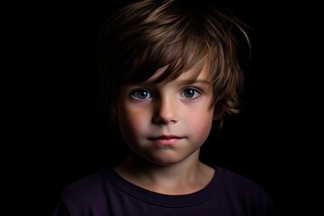 Portrait of a little boy with blue eyes on a black background