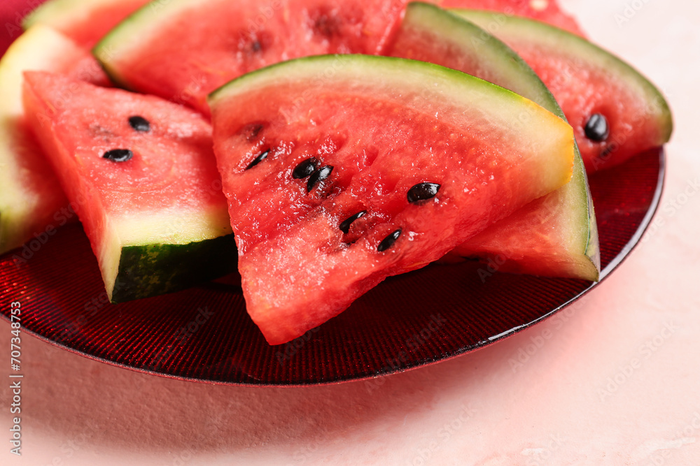 Plate with pieces of fresh watermelon on pink background