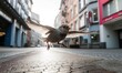 A sparrow flying low over a city street with buildings in the background
