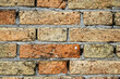 Weathered and eroded red brick background texture