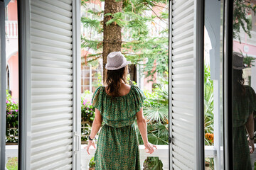 woman enjoying lush greenery in front of hotel room