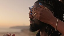 Closeup Of Unrecognizable Women's Hands Tenderly Covering An African Man's Face During A Beautiful Sunset, Expressing Love And Connection