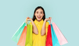Fototapeta Mapy - Emotional brunette woman showing colorful shopping bags