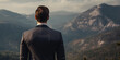 A vision of success: a businessman in a suit stands atop a mountain, contemplating the horizon, concept of goal attainment.