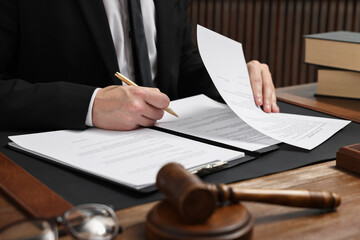 Sticker - Lawyer working with documents at wooden table in office, closeup