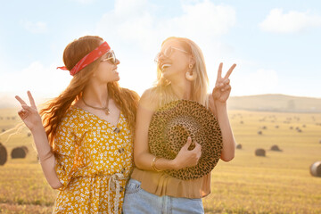 Poster - Beautiful happy hippie women showing peace signs in field