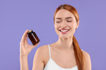 Poster - Happy young woman with bottle of pills on purple background. Weight loss