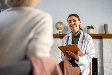 Asian caregiver nurse examine and listen to senior woman patient at home.