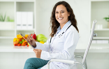 Wall Mural - Happy millennial european woman doctor nutritionist in white coat