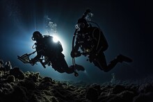 Moonlit Night Dive: Divers Exploring The Mysteries Of The Ocean Under A Moonlit Sky.