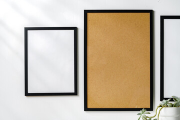 Three blank frames with copy space hanging on white wall