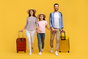 Happy Caucasian Family Of Three Holding Hands And Walking With Suitcases