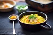 risotto with saffron in a black bowl and a spoon aside