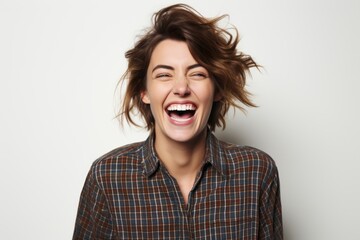 Wall Mural - Portrait of a happy young woman laughing and looking at camera.