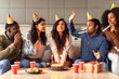© Prostock-studio - Students enjoying weekend birthday party, woman making wish indoors