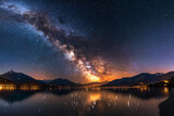 Fototapeta Niebo - Bright Milky Way over the lake at night panorama