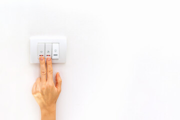 two females fingers on electric light switch on white background with copy space.