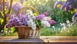 Wiklinowy kosz pełen kwiatów bzu stojący na deskach. W tle wiosenny ogród