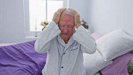 Poster - Stressed senior man in pyjamas suffering from intense headache pain in bedroom, hand on head depicting the ache of migraine - a portrait of unhappy elder's health problem