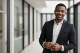 Fototapeta  - Professional black businessman smiling and looking at the camera against blurred outside office building background with copy space.