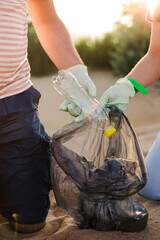 Volunteers collect trash, plastic garbage bottles on the beach. Ecology, environment, pollution and ecological problems concept