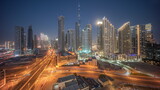 Fototapeta  - Aerial view of Dubai Downtown skyline with many towers day to night timelapse.