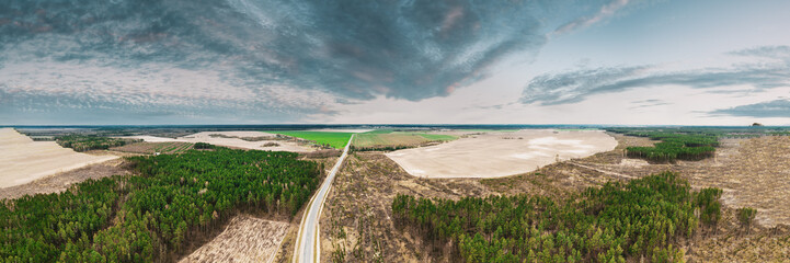 Canvas Print - Aerial View Of Highway Road Through Deforestation Area Landscape. Green Pine Forest In Deforestation Zone. Top View Of Field And Forest Landscape. Drone View. Bird's Eye View