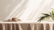 table counter with beige brown linen tablecloth drape in sunlight tropical leaf shadow on blank wall