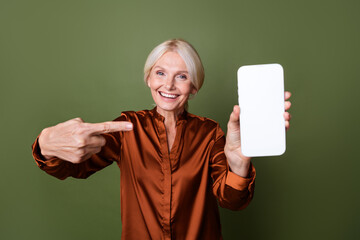 Sticker - Photo of satisfied woman dressed silk shirt directing at qr code on smartphone screen empty space isolated on green color background