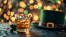 Crystal Glass Full Of Whiskey Next To A Shamrock, On A Dark Surface, With A Green Top Hat And Blurred Lights In The Background, Celebrating St. Patrick's Day
