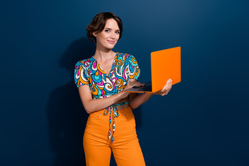 Photo of smiling happy young pretty woman using notebook for reviewing online propositions job offers isolated on blue color background