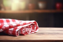 Picnic Cloth With Red Checker Pattern On Wooden Table, Empty Space. Towel Covering Blurred Kitchen Background.