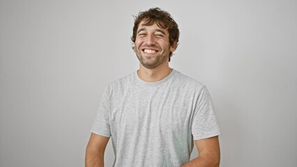 Canvas Print - Handsome young man adorably blowing a love-filled kiss at the camera, standing isolated on a white background, sporting a casual t-shirt