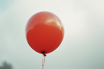 Poster - A person holds a red balloon in the air. Suitable for various occasions