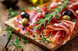 Italian prosciutto crudo or jamon with olives and rosemary