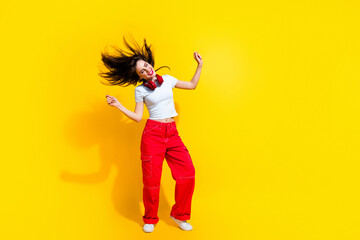 Sticker - Full length photo of dreamy cheerful woman dressed t-shirt headphones flying hair discotheque empty space isolated yellow color background