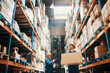 © Davor - Young man carrying box in large warehouse