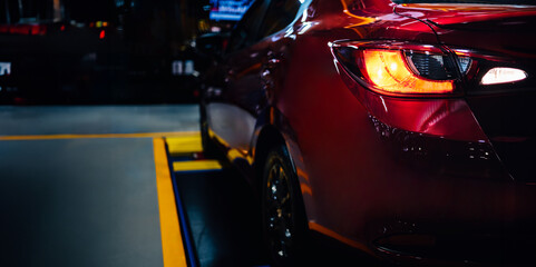 Expensive sports car concept. Modern luxury red cars, detail on one of the LED taillights modern car on black background.