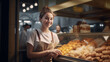 The image portrays a young woman with a bun, wearing an orange apron in a bakery with fresh bread.