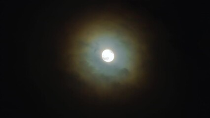 Wall Mural - Full moon in the night sky. The corona is a light optical phenomenon in the form of colored clouds around the Moon on a dark, cloudy night