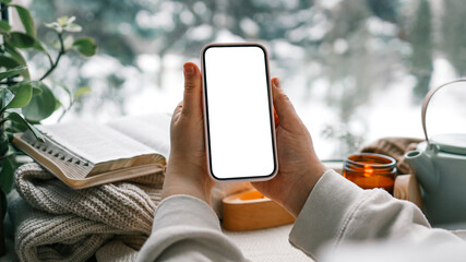 Wall Mural - Phone in hands with isolated screen on the background of the Bible