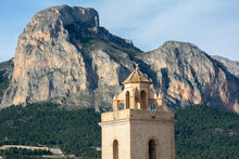 An Impressive Ponoig Mountain, Known Locally As ‘el Leon Dormido’ Seen With Belfry Of The Church Of San Pedro On The Foreground In  Polop In La Nucia, Spain