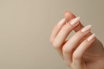 Wall Mural - Closeup to woman hands with elegant neutral colors manicure. Beautiful nude manicure on long almond shaped nails. Nude shade nail manicure with gel polish at luxury beauty salon