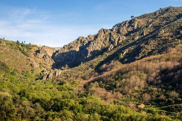 Canvas Print - Rocky mountain landscape with a wooded valley and the Caldeirão dam in the background, in the Serra da Estrela Natural Park in Portugal.