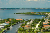 Fototapeta  - Aerial view of rural private houses in remote suburbs located on sea coast near Florida wildlife wetlands with green vegetation on gulf bay shore. Living close to nature in tropical region concept
